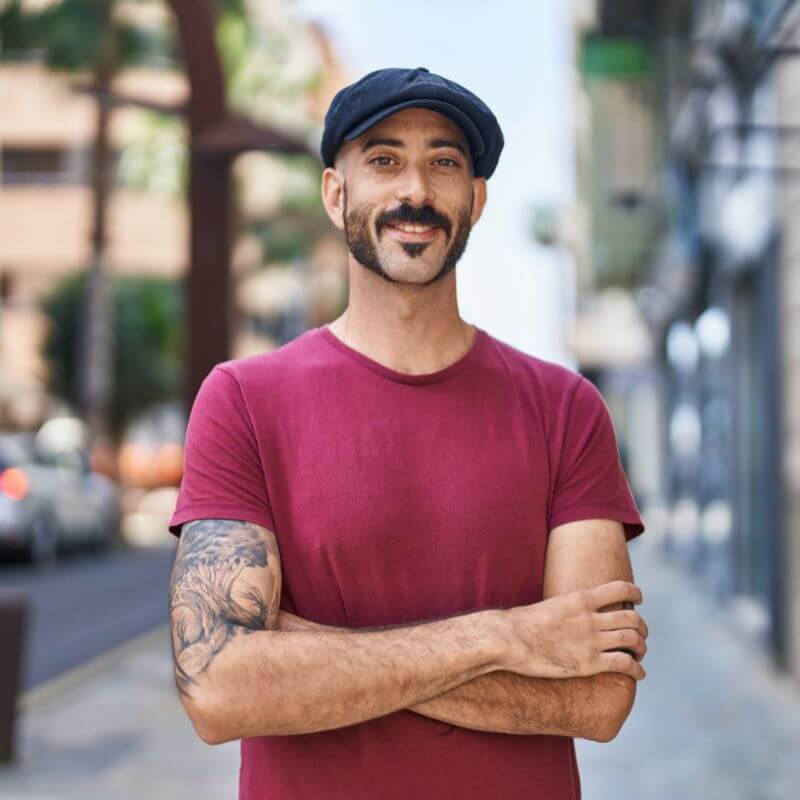 Image d'un homme souriant qui porte une casquette gavroche